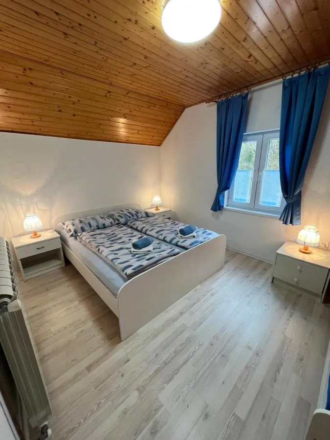 Spalnica z modrimi zavesami in nočnima omaricama