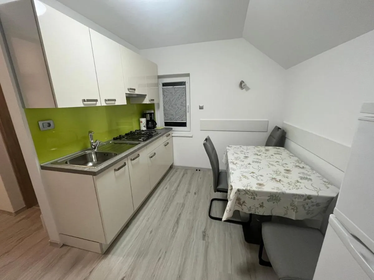 Svetla kuhinja z jedilno mizo v Modrem apartmaju