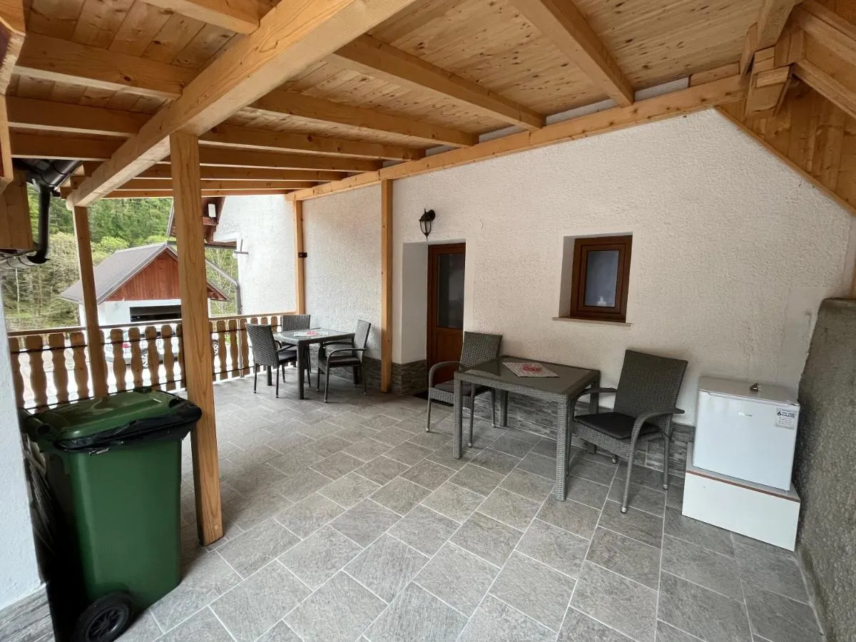 Pokrita terasa z mizo in stoli pred Modrim apartmajem