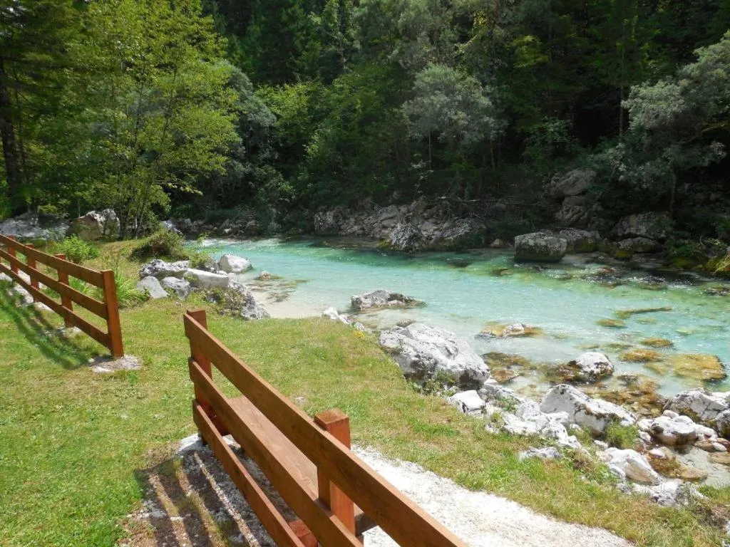 Lesena ograja vrta in stopnice do smaragdne Soče