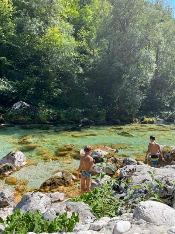 Otroka v plitvi Soči med kamni