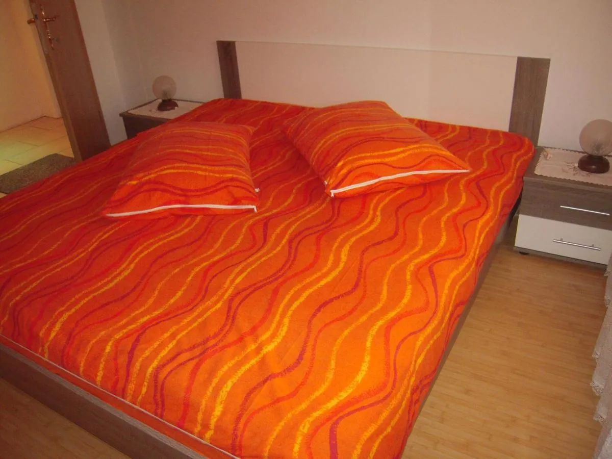 Zakonska postelja z oranžnim pregrinjalom